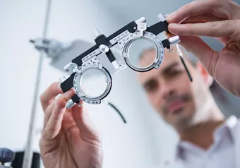 Image of optician holding a trial frame
