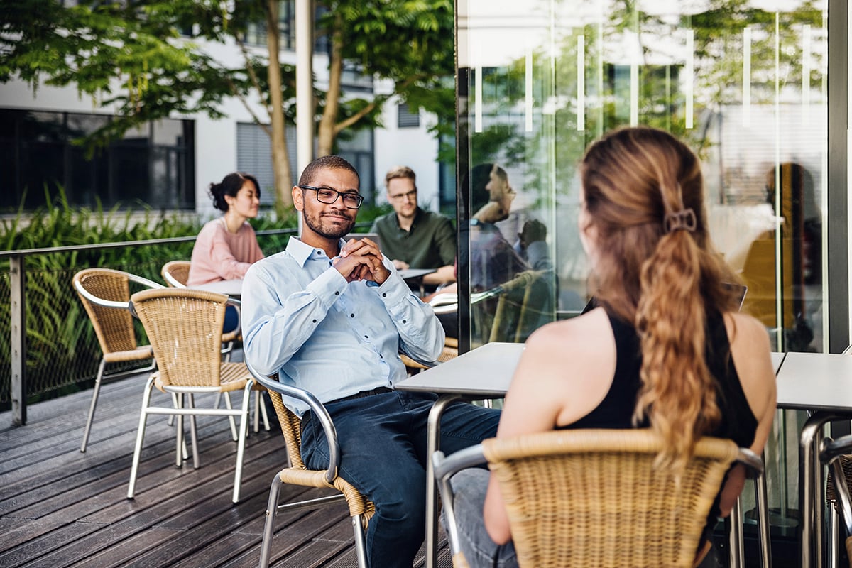 Man with glasses having a conversation with a blonde lady