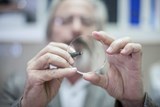 Image of optician holding a lens