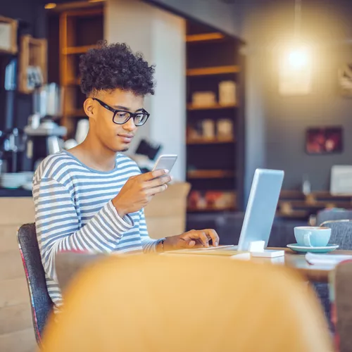 Image of a male wearing glasses whilst in a coffee shop