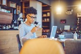 Image of a male wearing glasses whilst in a coffee shop