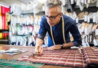 Landscape image of male whilst working with fabric 