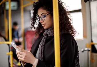 Landscape image of female wearing glasses whilst on public transport 