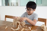 Landscape image of child wearing glasses whilst playing on the kitchen table