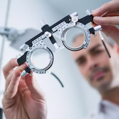 Image of optician holding a trial frame