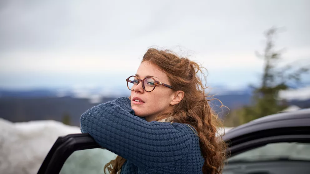 Woman with glasses leans over car door | Femme avec des lunettes se penchant sur la portière de la voiture.