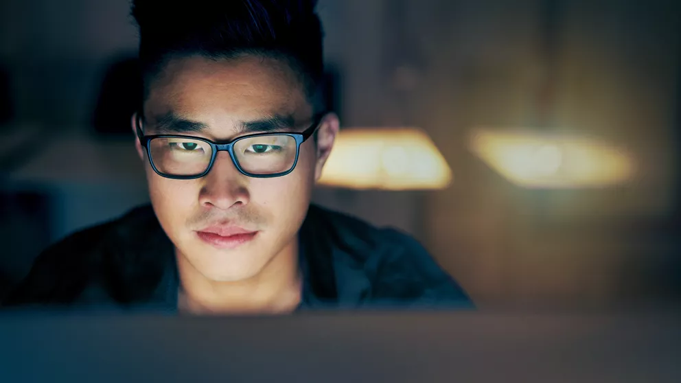 Young man looking at computer screen with single vision lenses