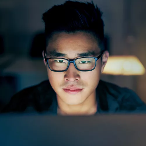 Un giovane uomo guarda lo schermo del computer con lenti monofocali