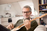 OIder man wearing HOYA progressive lenses while playing guitar
