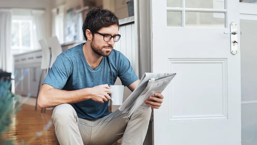 Man with occupational lenses reading newspaper