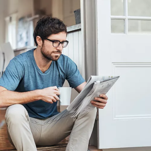 Hombre con lentes ocupacionales leyendo el periódico