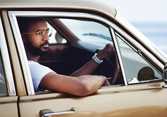 Man with glasses driving a car