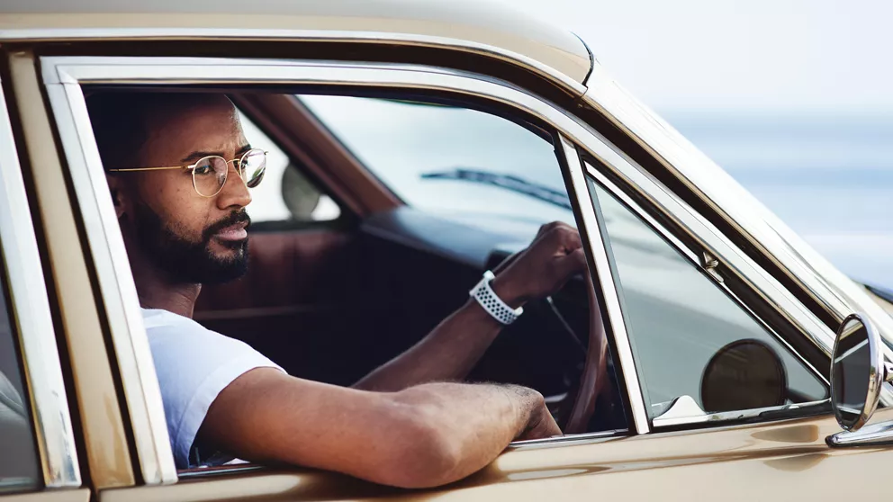 Man with glasses driving a car