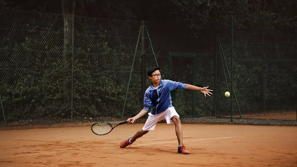 Man wearing special HOYA sport lenses while playing tennis