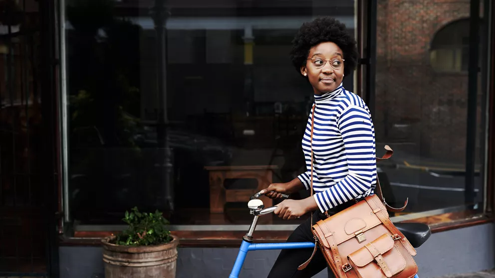 Lady with glasses riding a blue bike