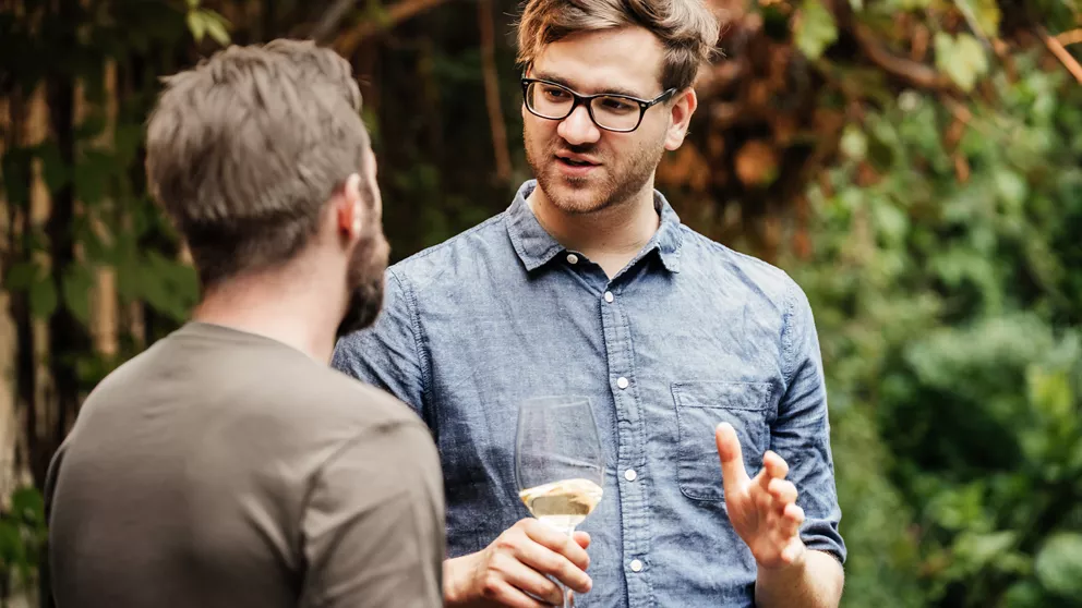 Young man wearing glasses having a conversation with a friend