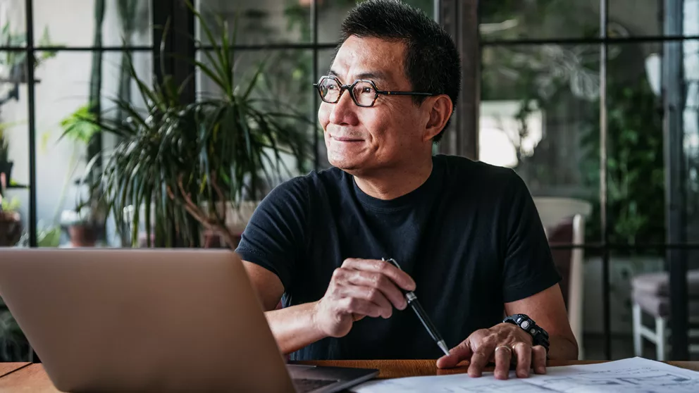 Man with blue light glasses working at a laptop