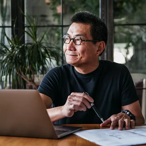 Hombre con gafas de luz azul trabajando en una computadora portátil