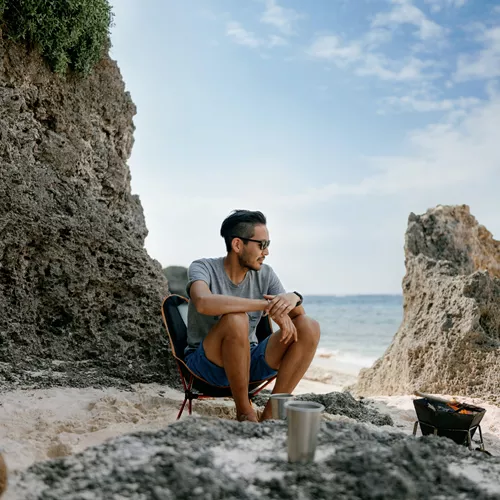 Uomo che indossa occhiali da sole polarizzati HOYA sulla spiaggia