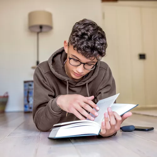 Boy wearing MiYOSMART glasses reading book