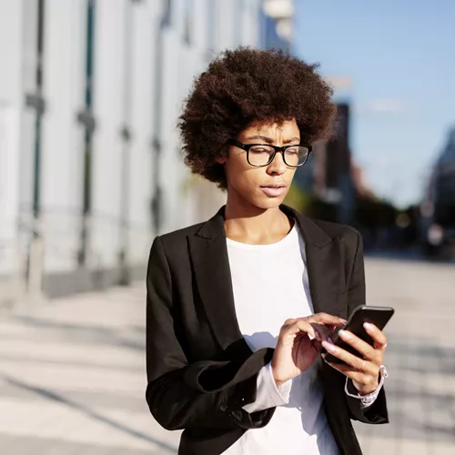 Signora con gli occhiali che guarda il cellulare