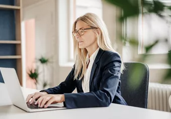 Woman working on a laptop with occupational glasses