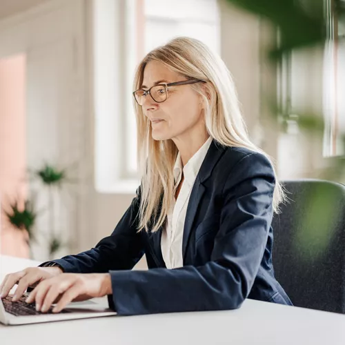 Woman working on a laptop with occupational glasses