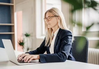 Woman working on a laptop with occupational glasses