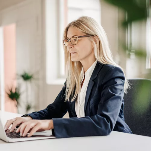 Woman working on a laptop with occupational glasses