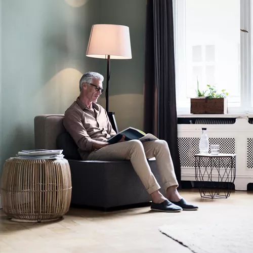 Older man wearing occupational lenses reading a book