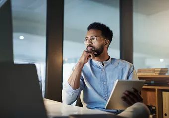 Man with blue shirt wearing occupational lenses while looking at screens
