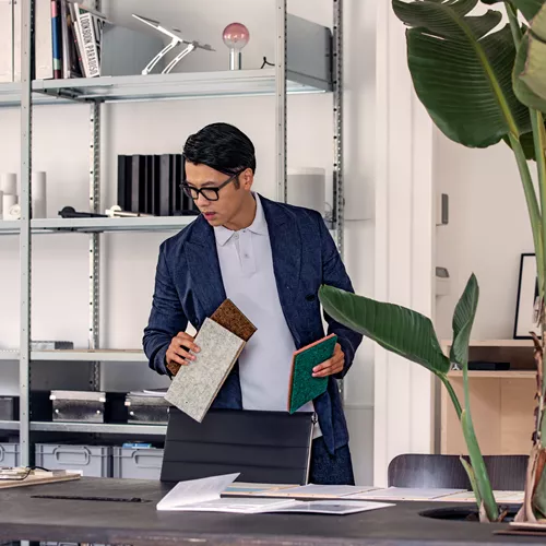 Interiordesigner wearing a suit and black framed glasses in his work room