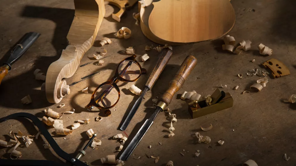 Violin builder's tools with glasses with HOYA occupational lenses.