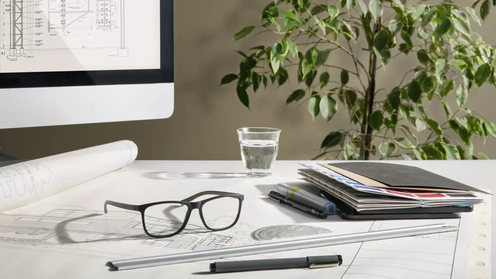 Architect's workspace featuring a pair of glasses with HOYA occupational lenses