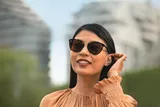 Smiling lady wearing sunglasses and orange top