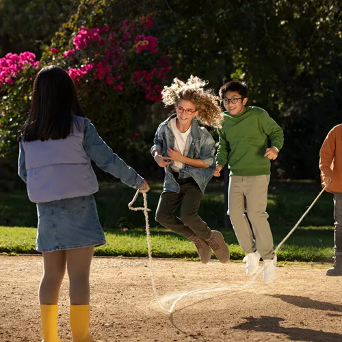 Four children playing outside while wearing glasses