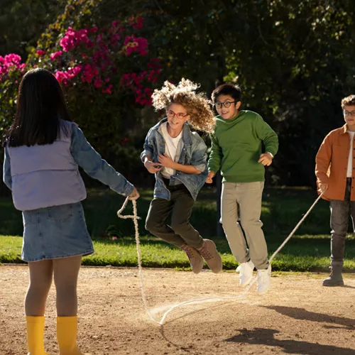 Children with myopia glasses skipping outside