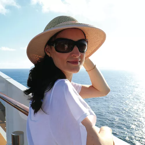Woman with straw hat and HOYA polarized sunglasses looking at the ocean