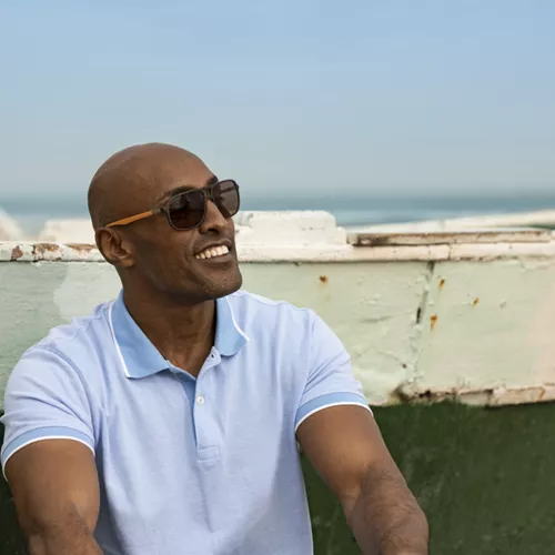 Smiling man wearing HOYA polarized sunglasses outside