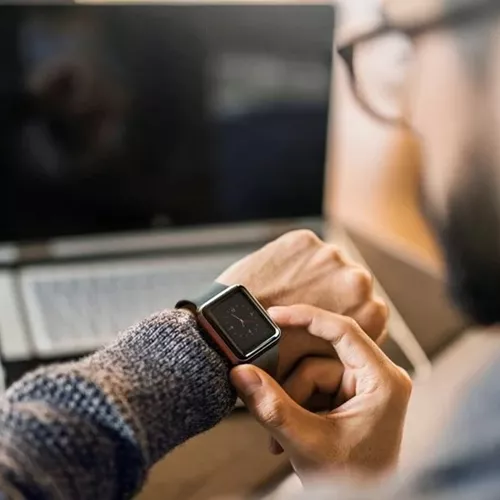 Uomo con gli occhiali che guarda l'orologio