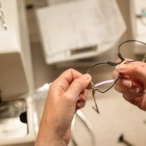Optician holding pair of glasses