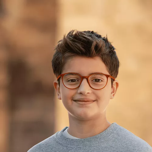 Smiling boy wearing HOYA MiYOSMART glasses