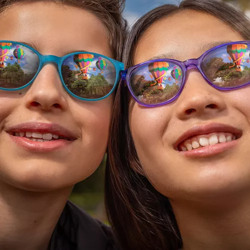 Two kids wearing reflective HOYA MiYOSMART sun spectacle lenses