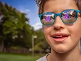 Bližnji posnetek dečka, ki nosi odsevna sončna očala HOYA MiYOSMART