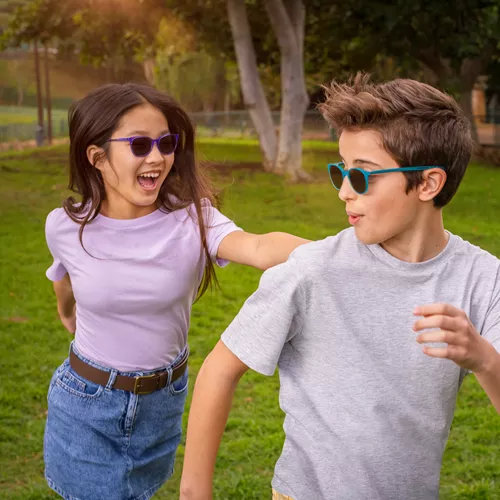 Boy and girl playing outside wearing HOYA MiYOSMART sunglasses