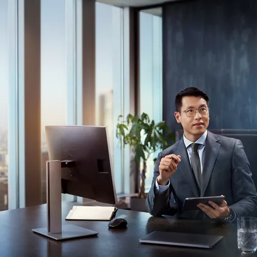 Man in suit behind desk, wearing HOYA MySelf Profile glasses