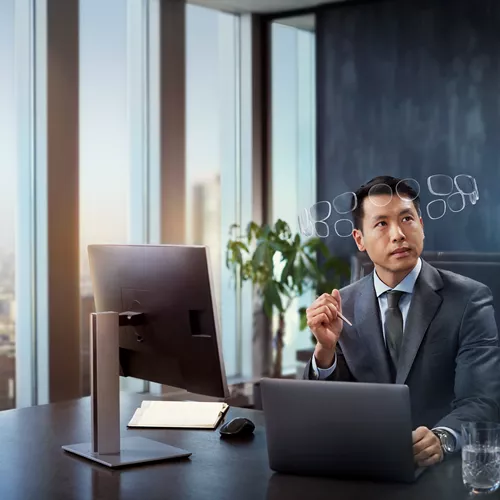 Man in suit behind desk, wearing HOYA MySelf Profile glasses with a halo of lenses around his head