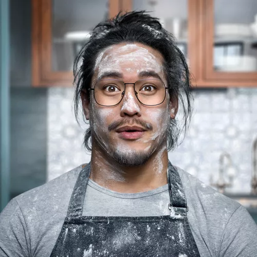 Überrascht aussehender Bäcker mit Mehl im Gesicht trägt eine saubere Brille mit HOYA Hi-Vision Meiryo-Gläsern