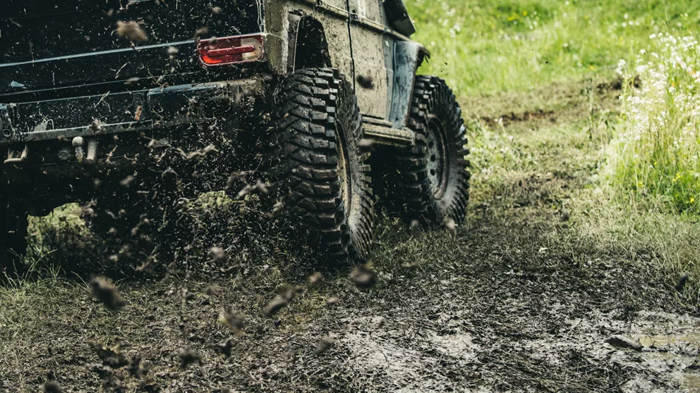 Four wheel drive car driving off-road in mud