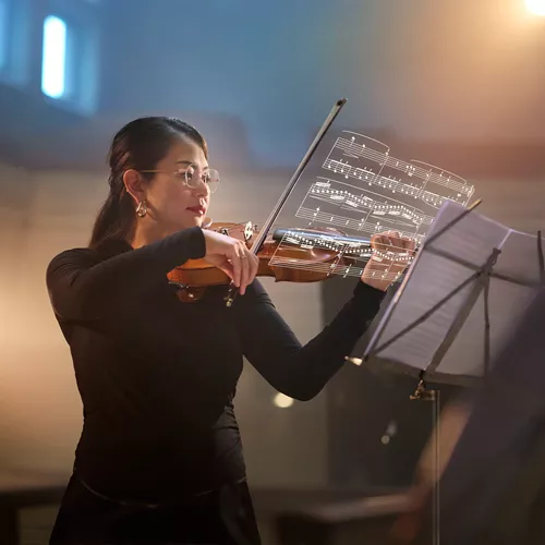 Female violinist wearing HOYA VisuPro lenses plays from sheet music